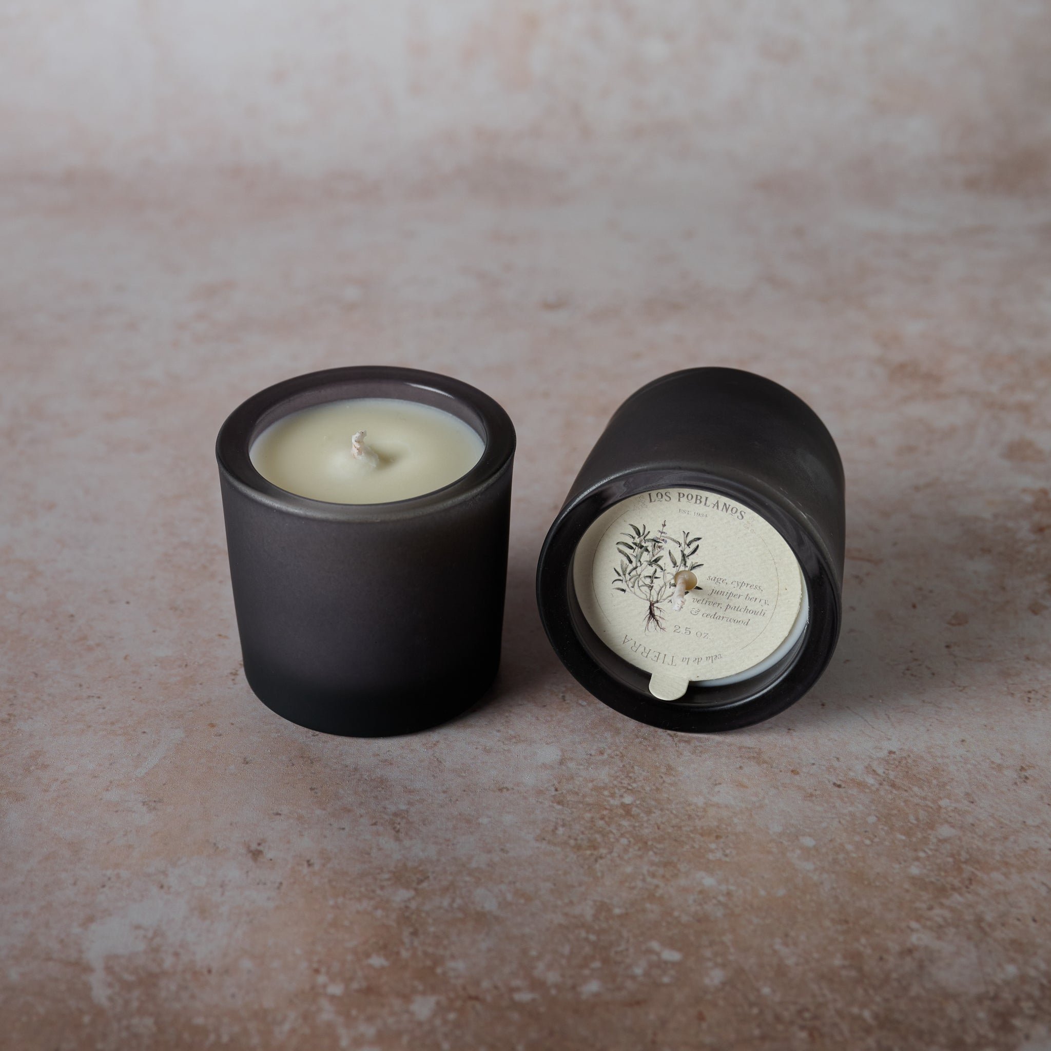 Two black candles on a textured surface