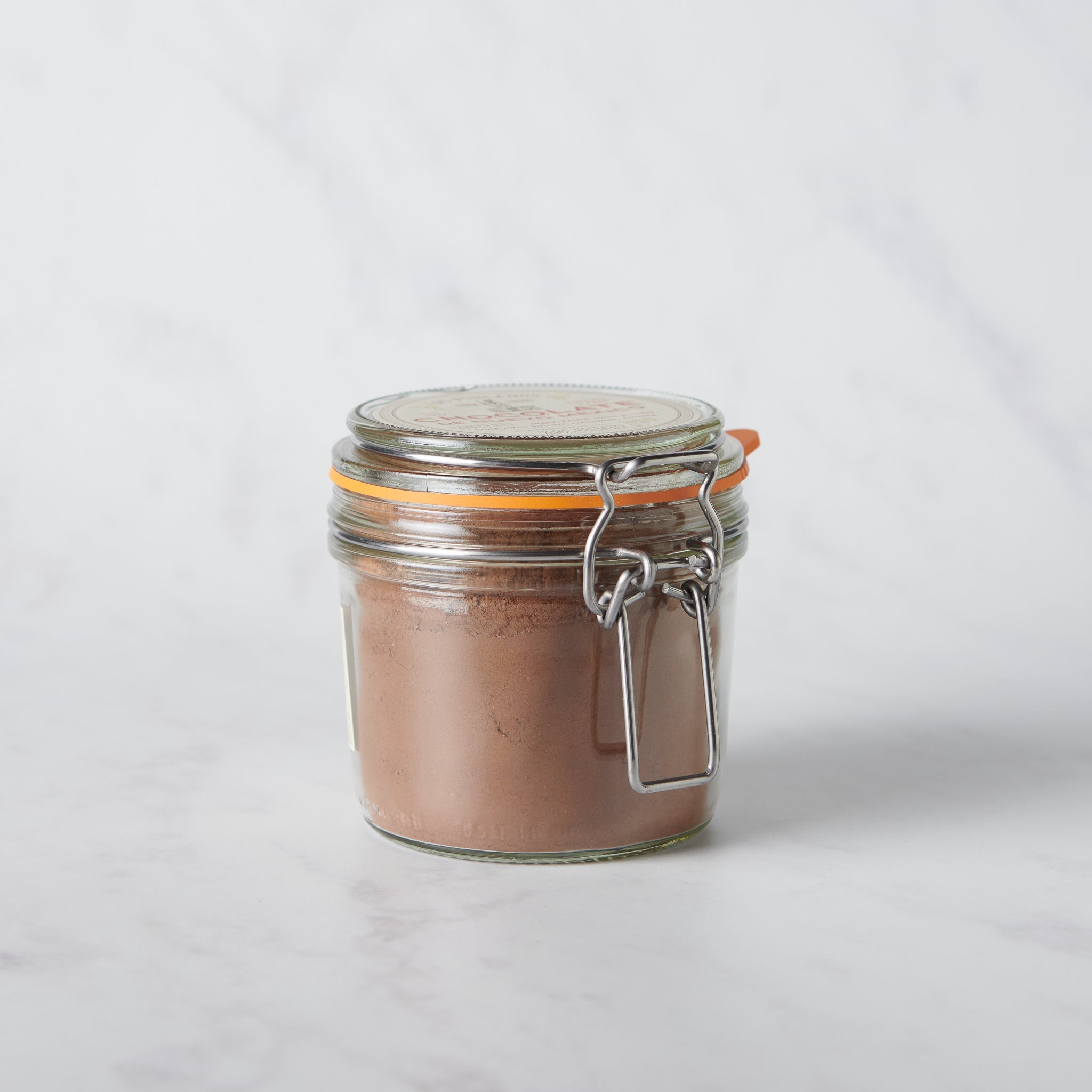 Chocolate de Nuevo México artisanal chocolate powder in a reusable glass jar inspired by regional flavors.