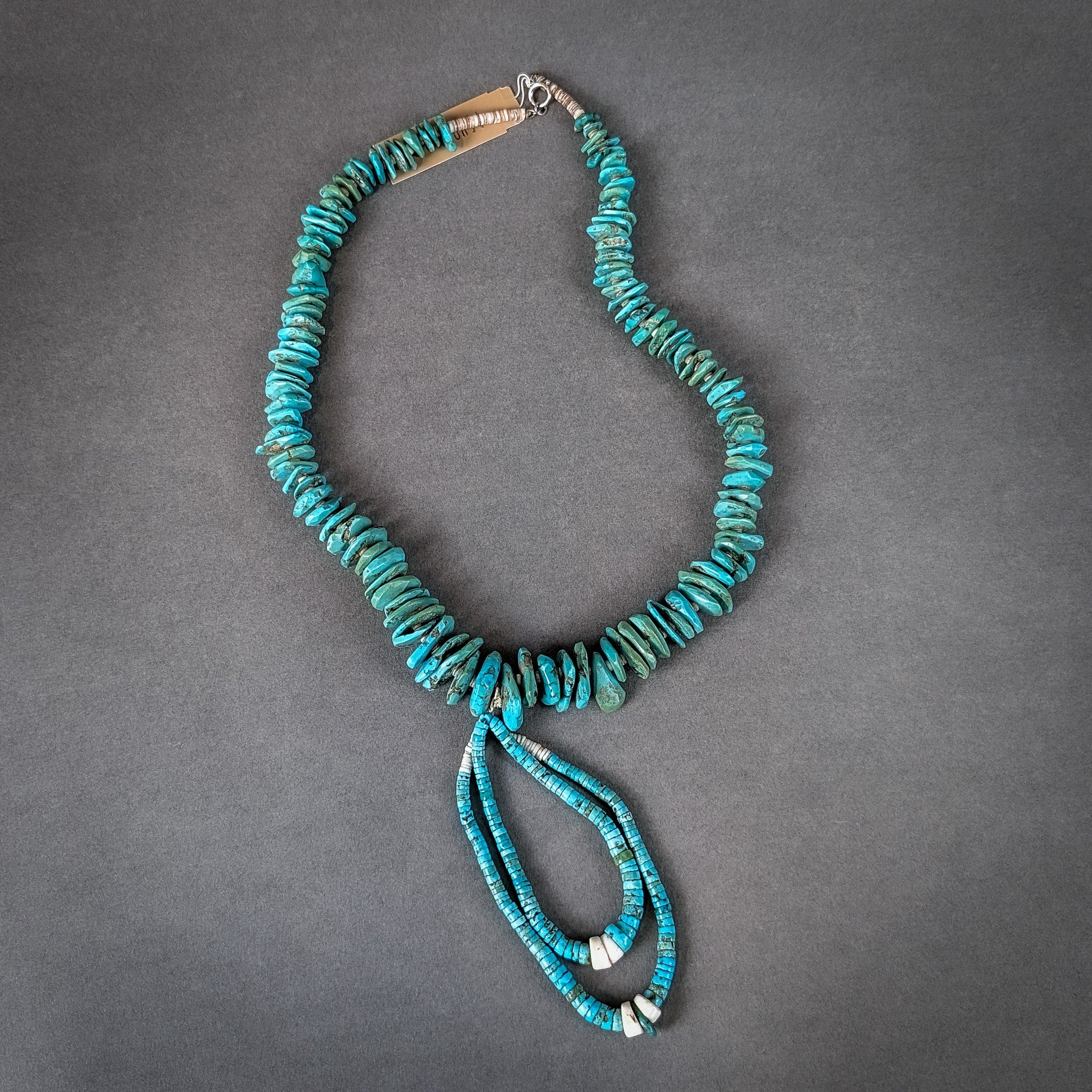 Turquoise beaded necklace on a gray background