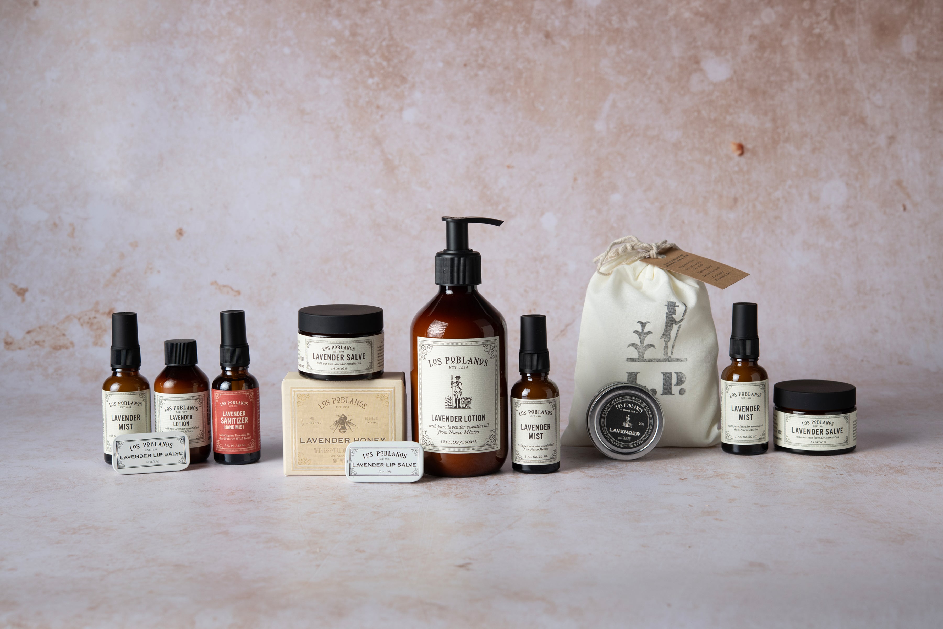 Collection of skincare and grooming products on a textured surface with a neutral background