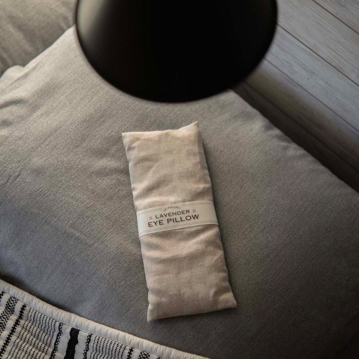 Lavender eye pillow on a gray pillow with a blurred background | Lavender Eye Pillow | Los Poblanos Online Shop