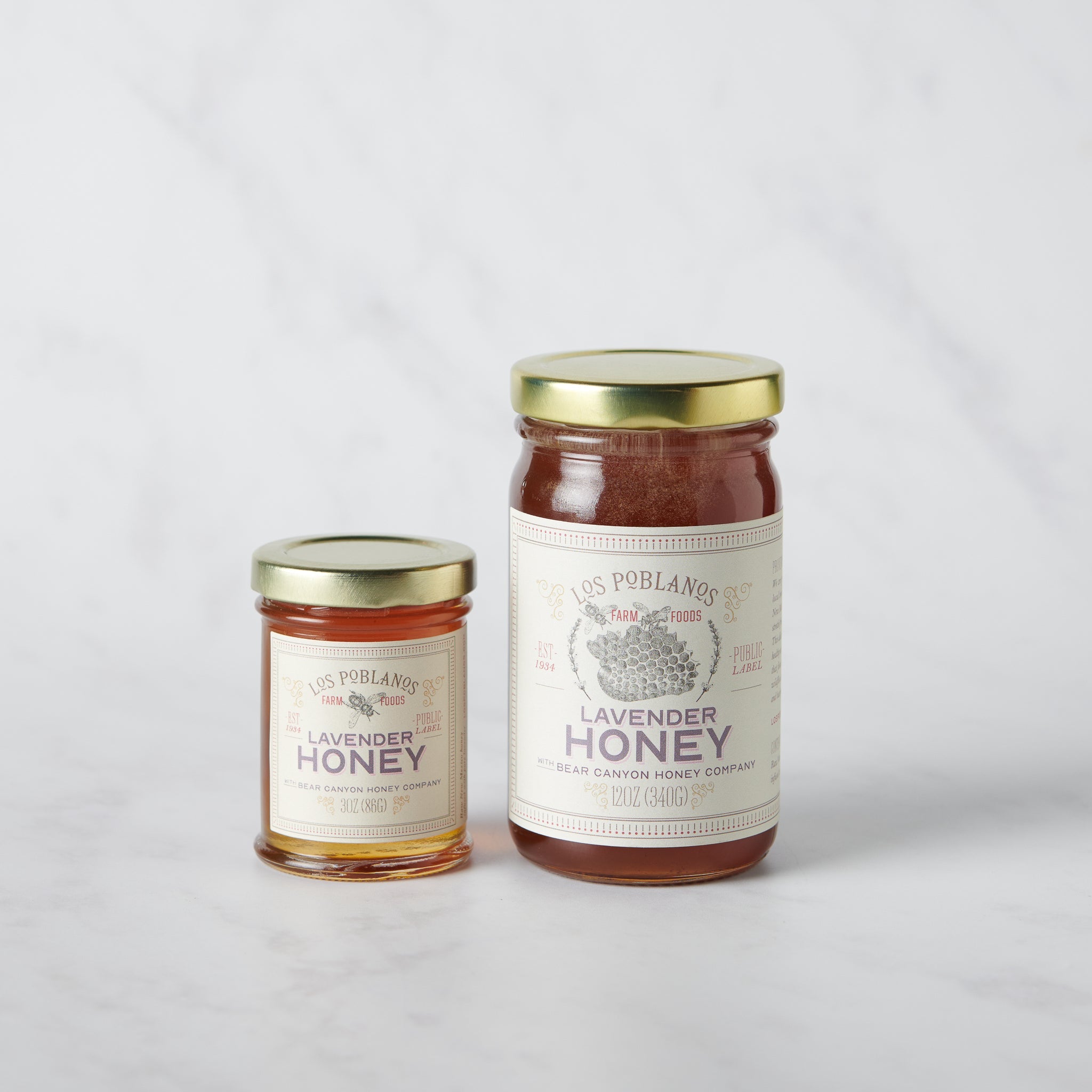 Two jars of lavender honey with gold lids on a light gray background | Lavender Honey | Los Poblanos Farm Shop