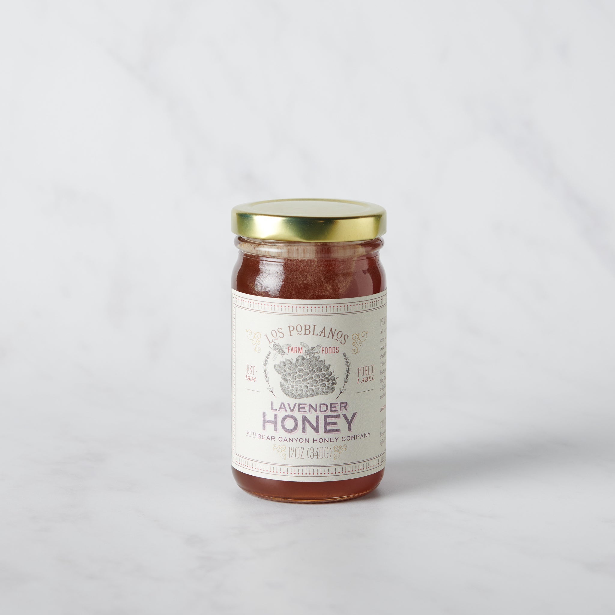 Jar of lavender honey with a gold lid on a light gray background | Lavender Honey | Los Poblanos Farm Shop