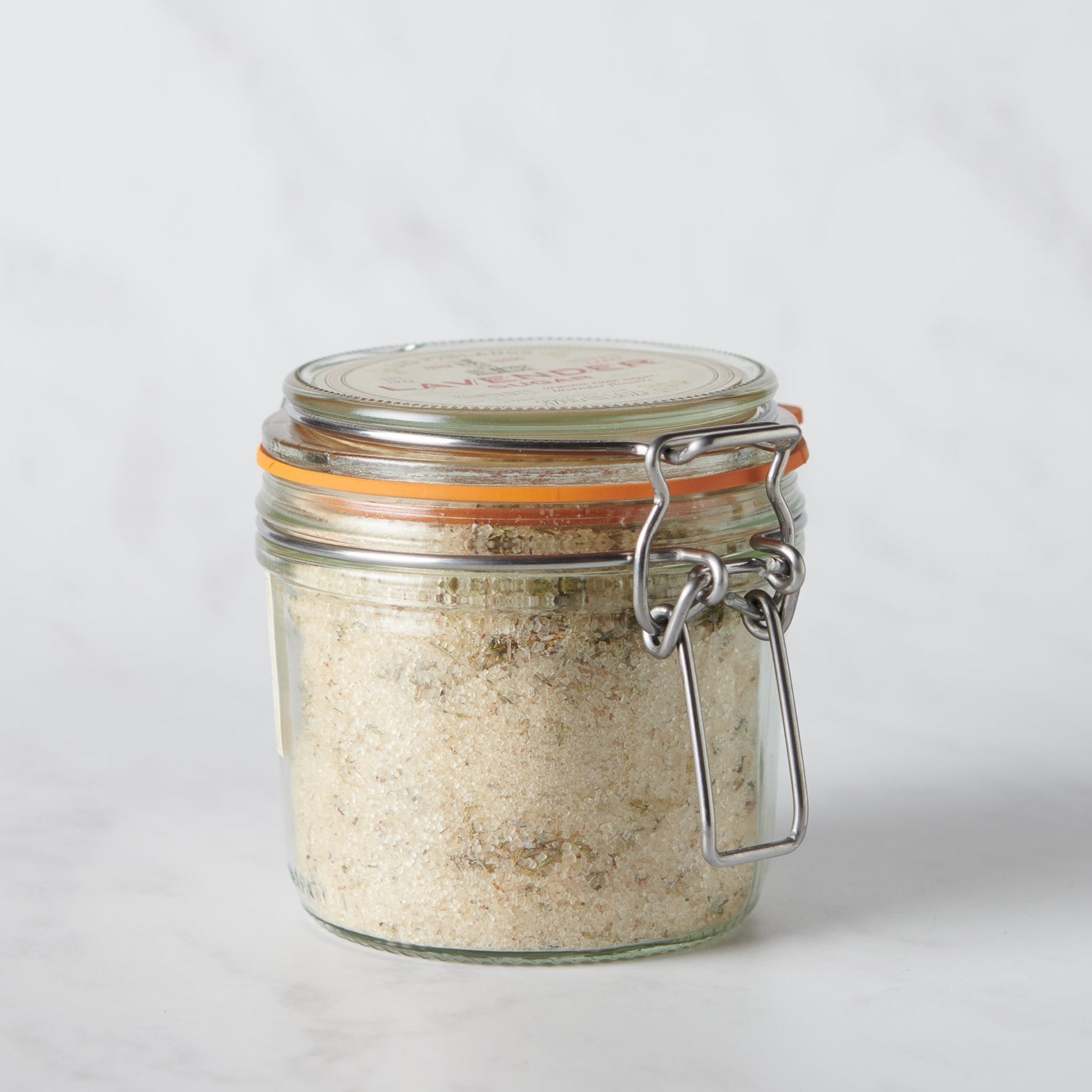 Glass jar with a metal clasp on a light gray background
