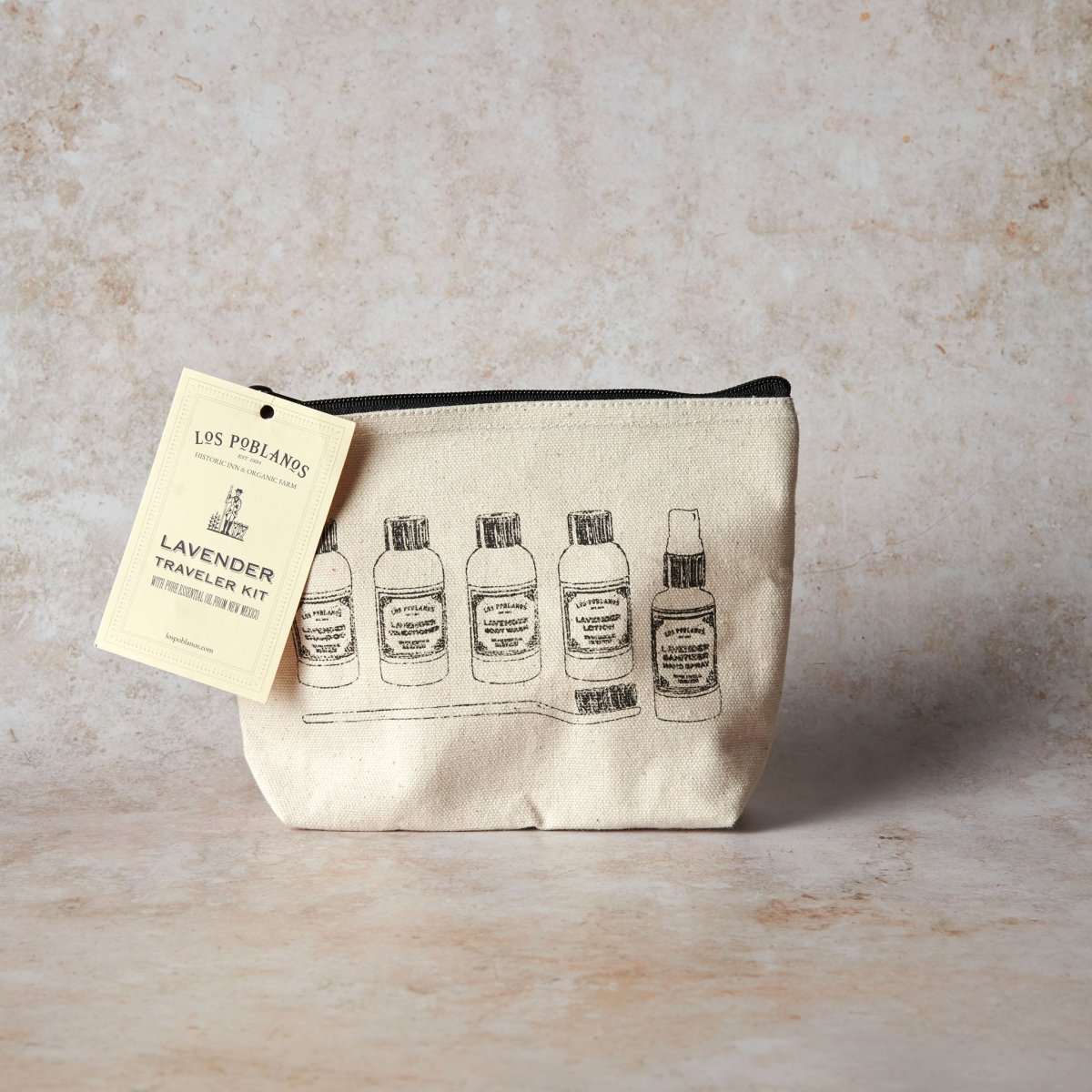 Cosmetic pouch with lavender-themed design and product tag on a textured surface