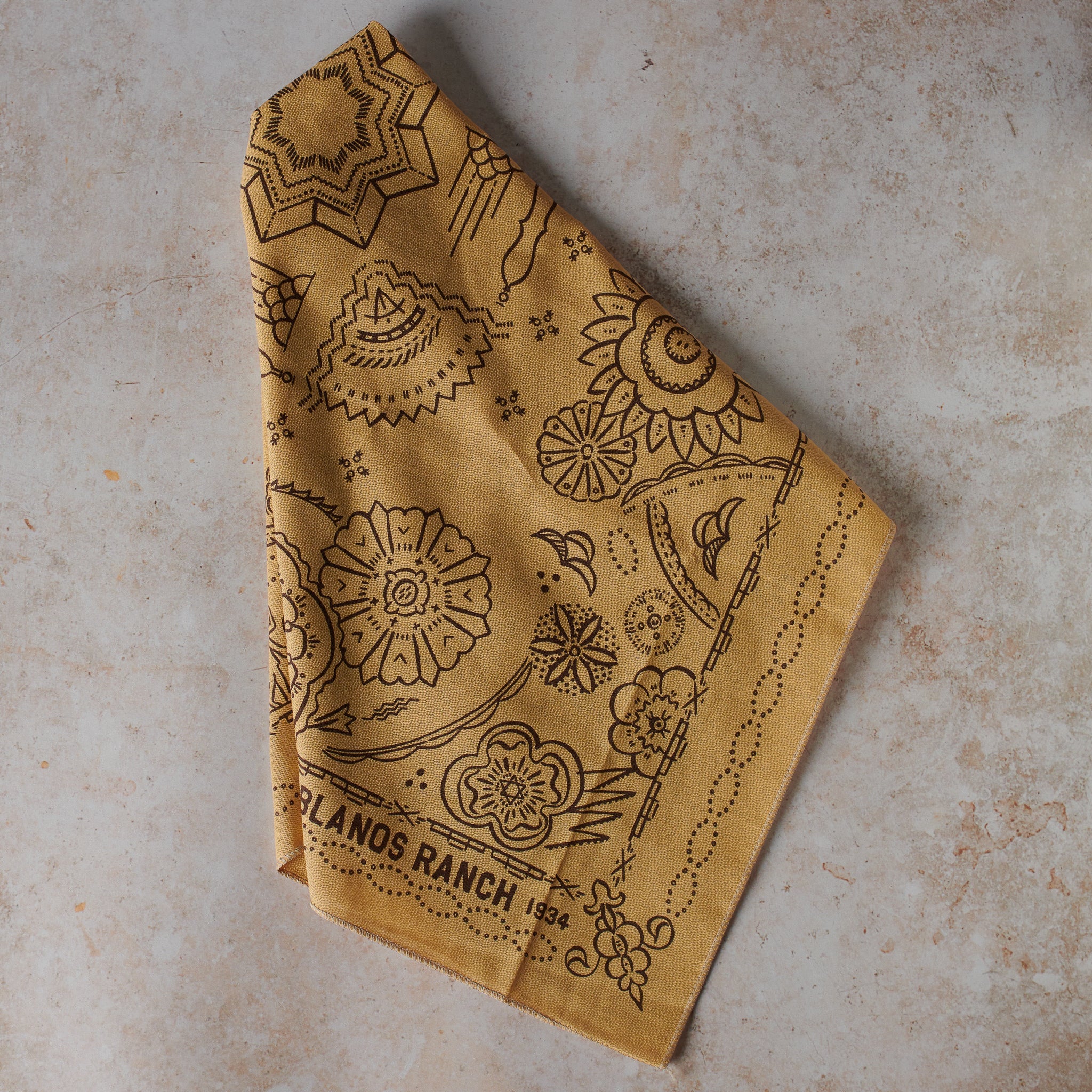 one khaki bandana, with intricate Southwestern-inspired patterns on a textured surface.
