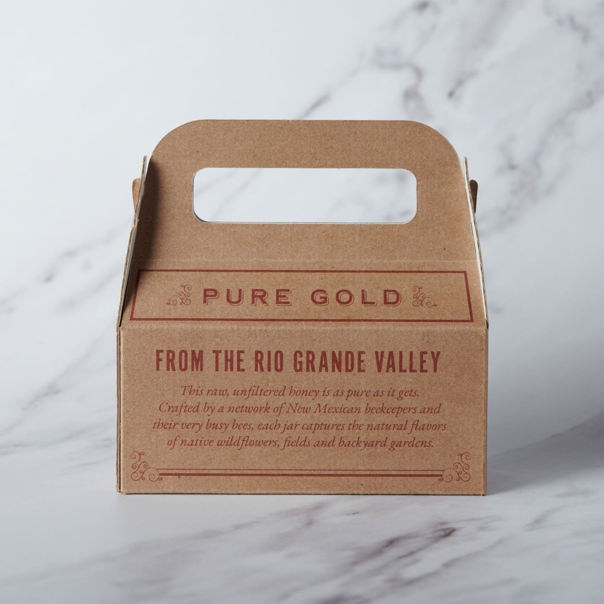 Brown cardboard box with 'Pure Gold' text on a marble surface