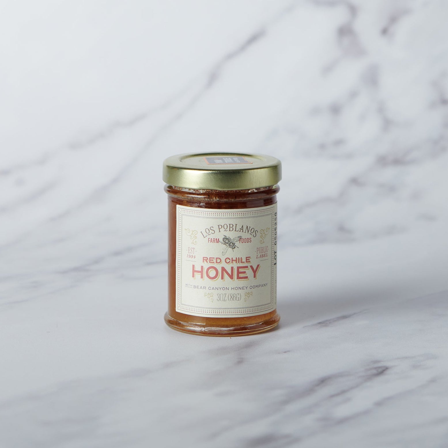 Jar of honey with a label on a marble surface