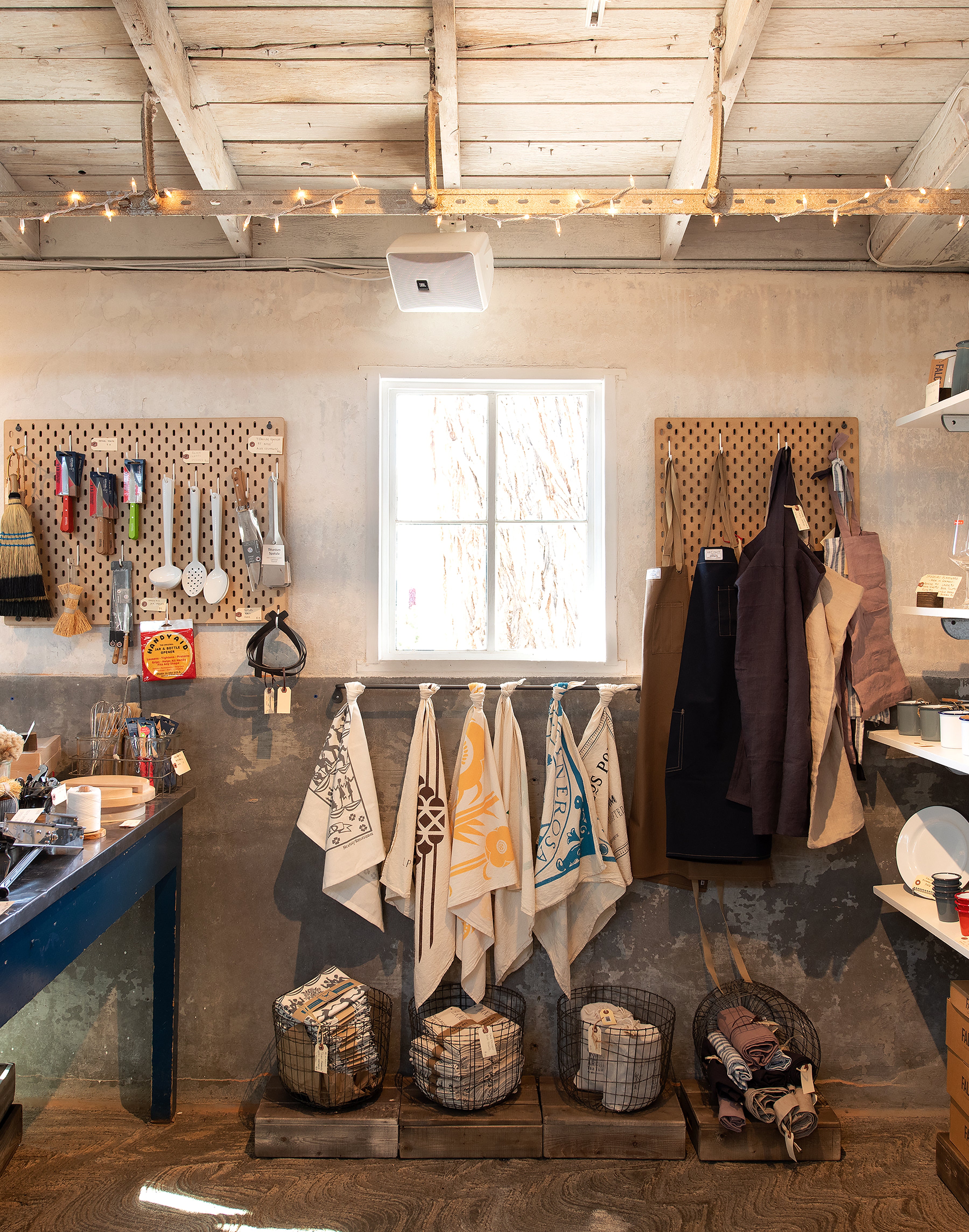 Workshop or garage interior with tools, pegboards, and hanging towels.