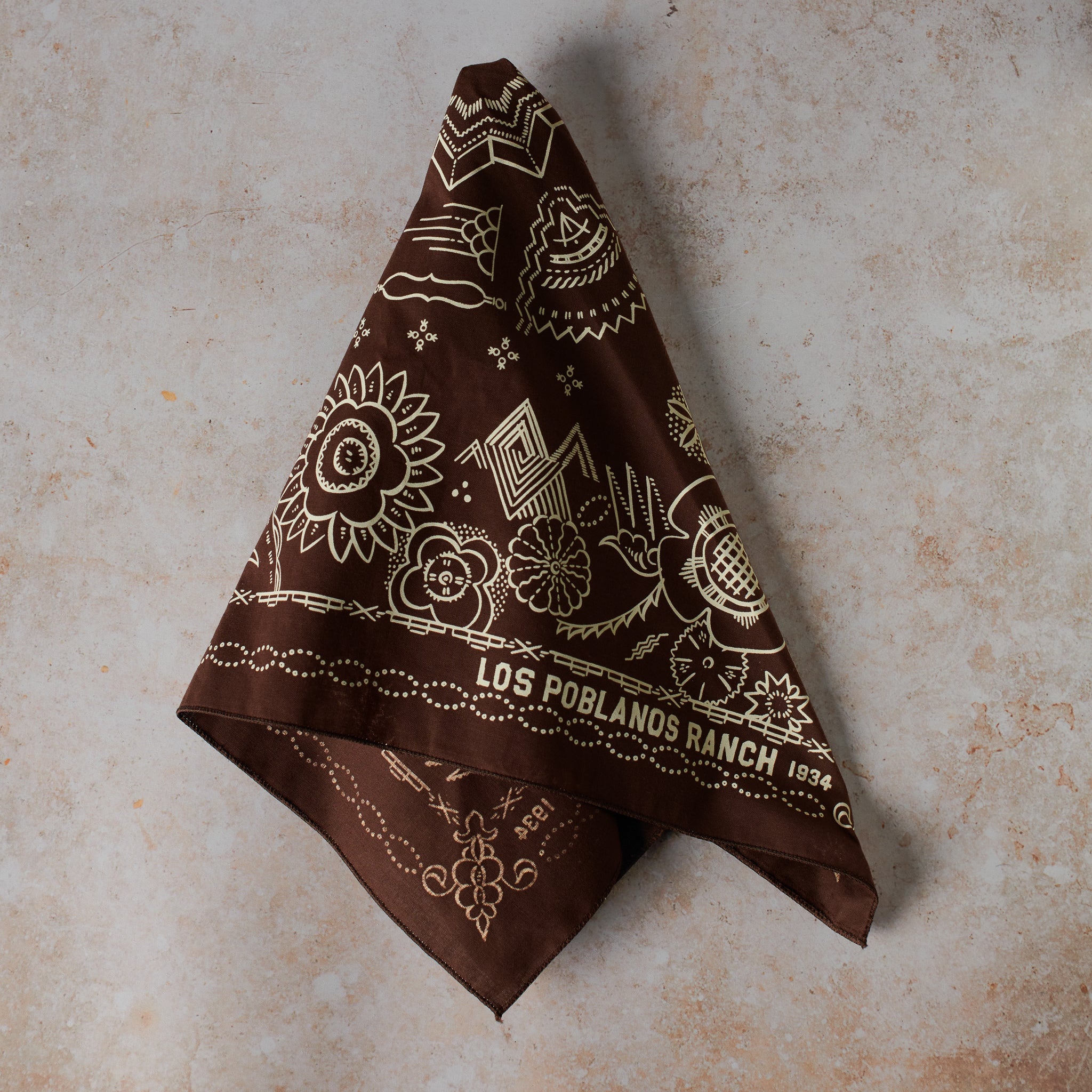 one chocolate bandana, with intricate Southwestern-inspired patterns on a textured surface.