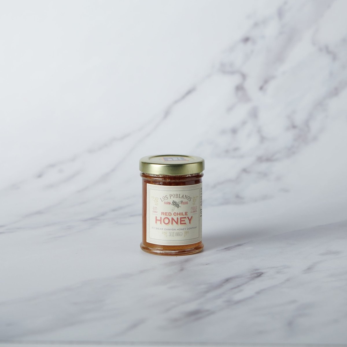 Jar of honey with a label on a marble surface