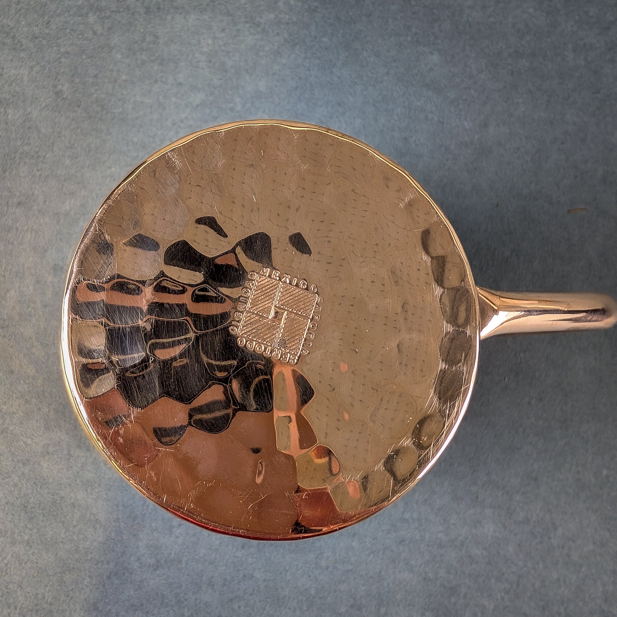 copper mug with decorative handle on a gray background