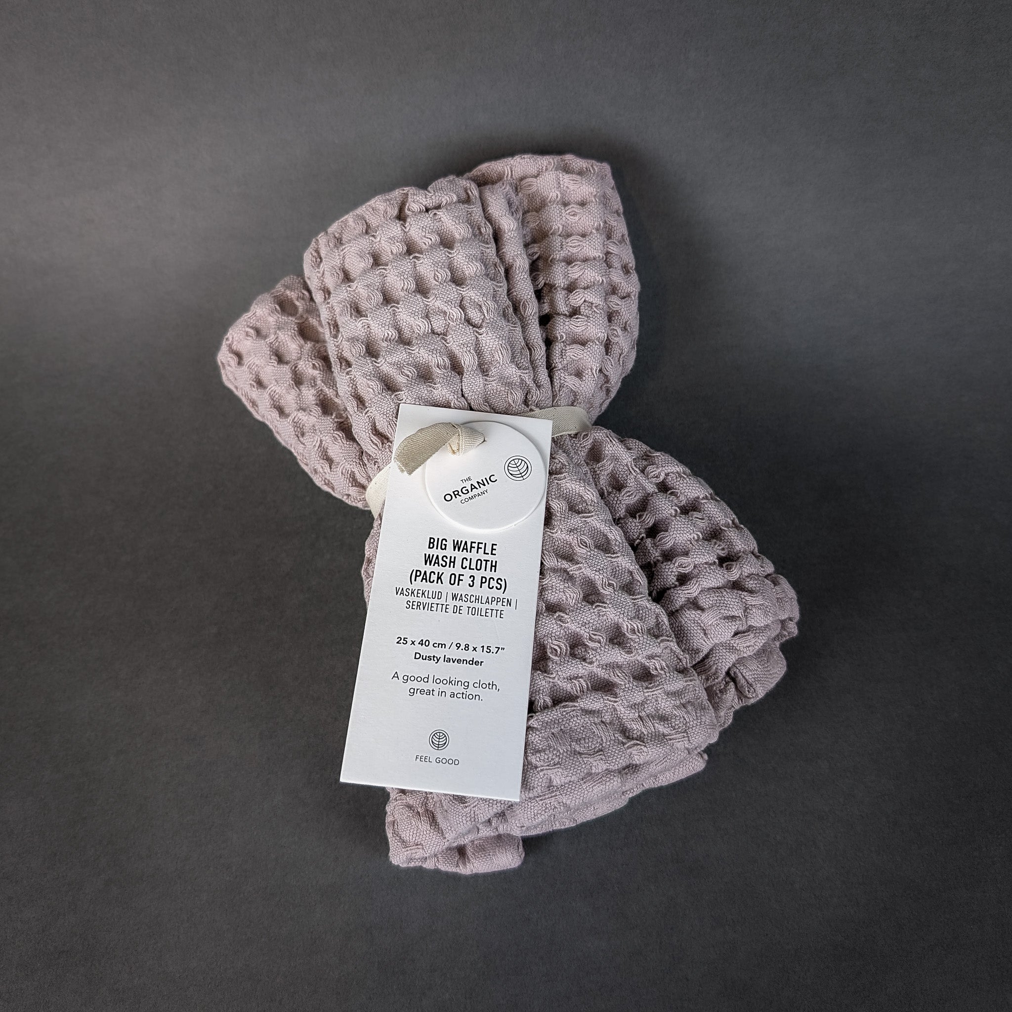 Folded waffle blanket with a tag on a dark gray background
